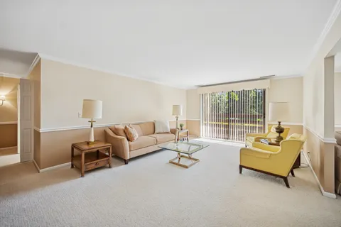 a living room with furniture and floor to ceiling window