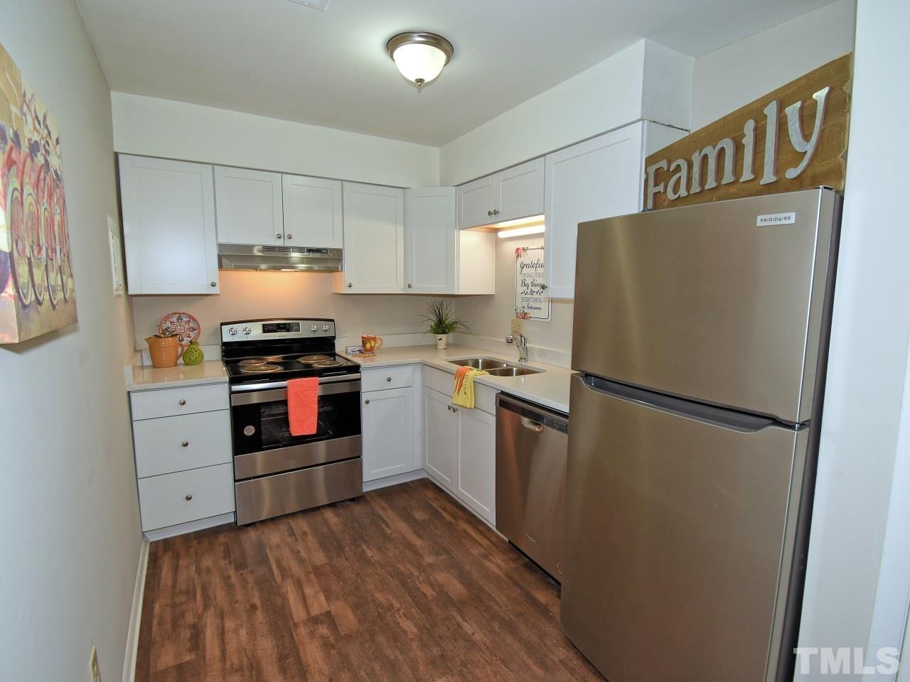 1000 Sandlin Place, Unit A Raleigh, NC 27606 - Photo 5 of 17 a kitchen with stainless steel appliances a refrigerator stove and sink