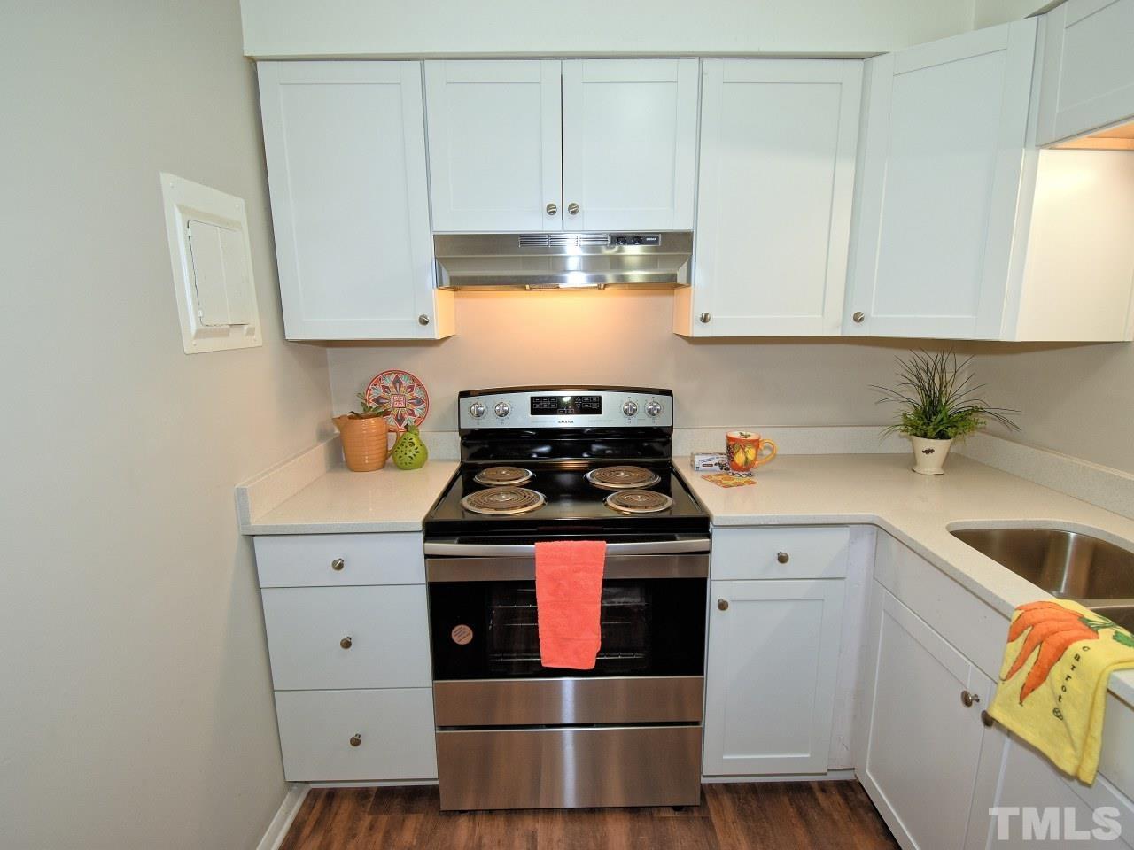 1000 Sandlin Place, Unit A Raleigh, NC 27606 - Photo 6 of 17 a kitchen with a stove and white cabinets