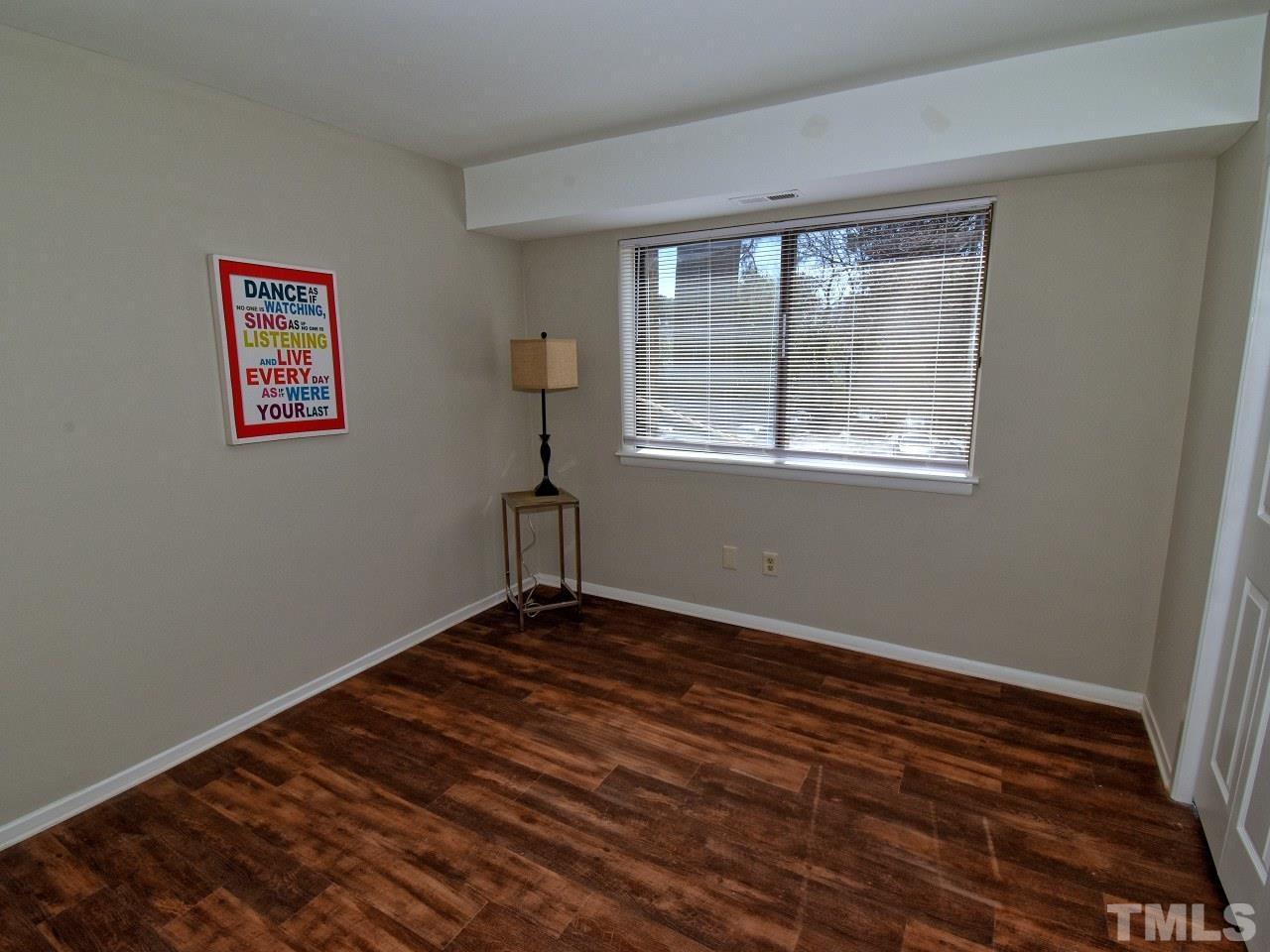 1000 Sandlin Place, Unit A Raleigh, NC 27606 - Photo 10 of 17 a view of an empty room with wooden floor and a window