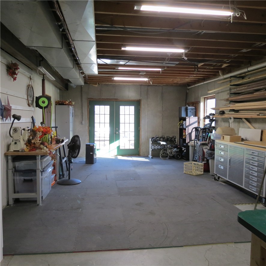 10160 Lochard Road Sidney, OH 45365 - Photo 31 of 41 Functional basement space with an exterior entry and exposed ceiling beams, ready for various uses.