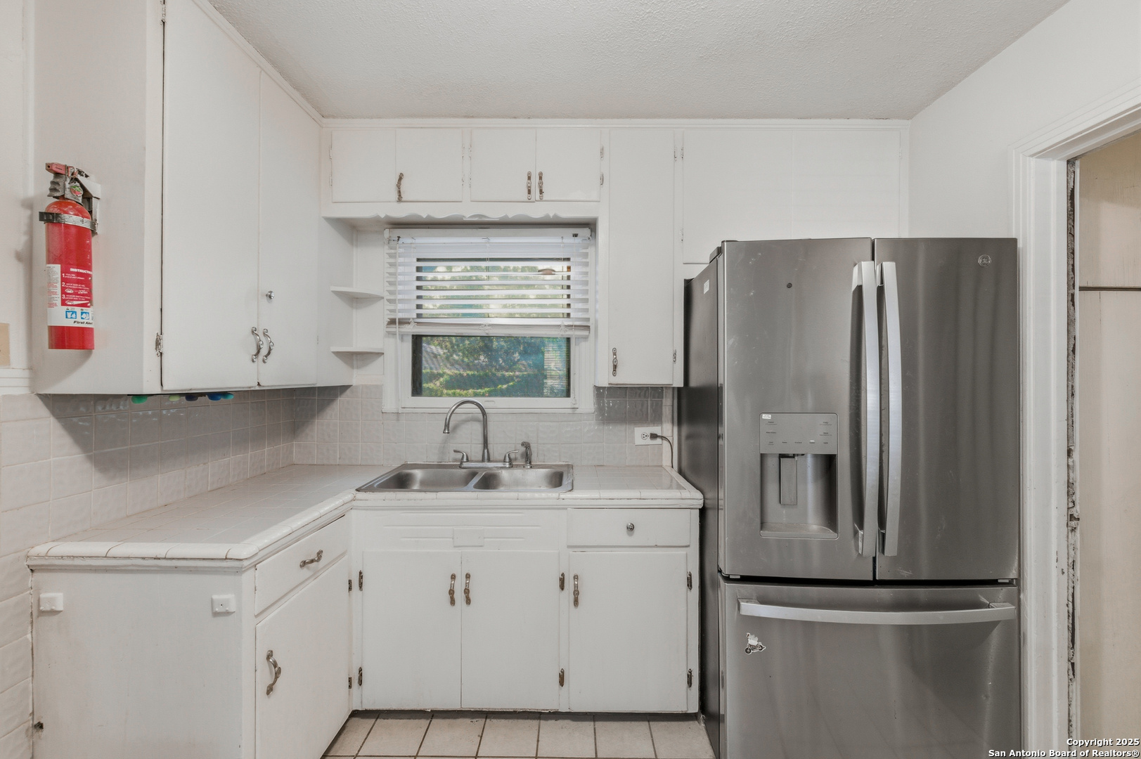 118 Raleigh Place San Antonio, TX 78201 - Photo 11 of 25 a kitchen with a refrigerator sink and cabinets