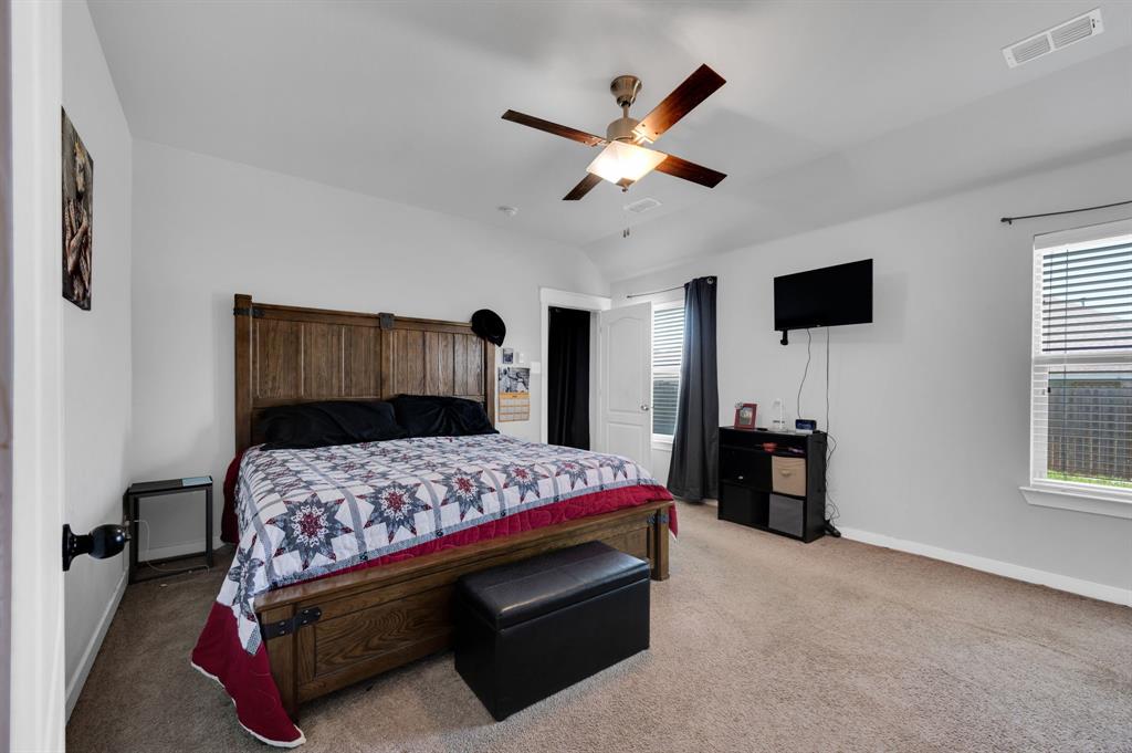 2609 Centurion Road Glenn Heights, TX 75154 - Photo 16 of 29 Bedroom with light colored carpet, a ceiling fan, multiple windows, and lofted ceiling