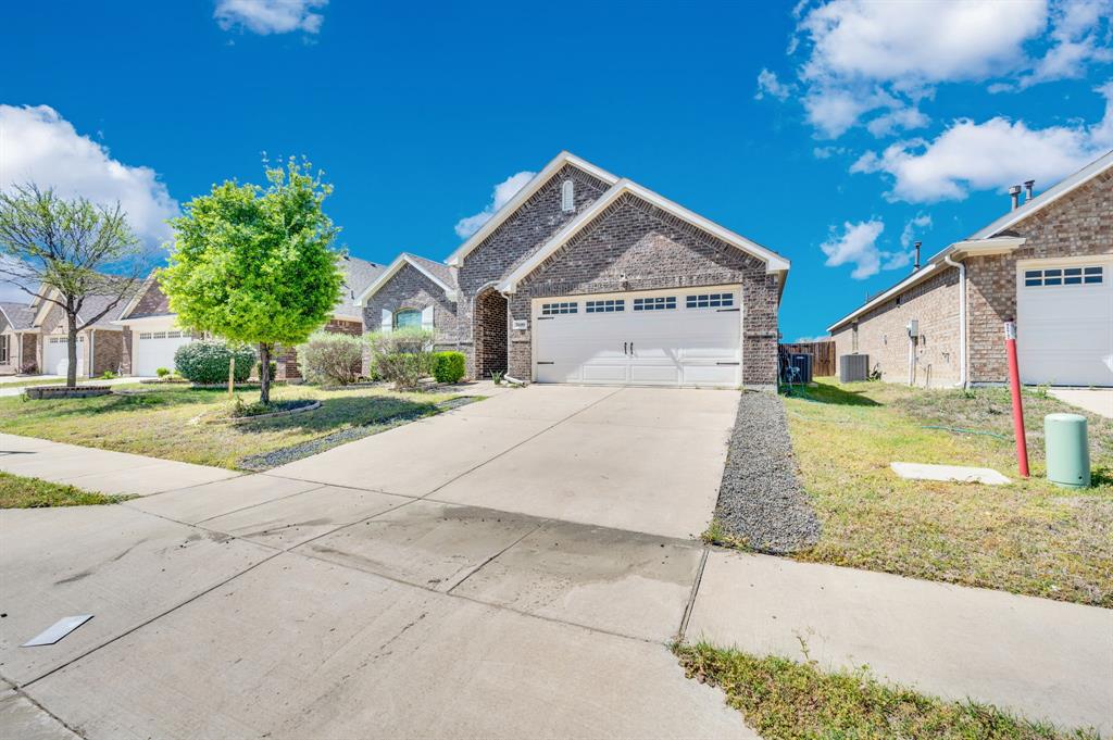 2609 Centurion Road Glenn Heights, TX 75154 - Photo 28 of 29 View of front of home with brick siding, an attached garage, concrete driveway, a front yard, and a residential view