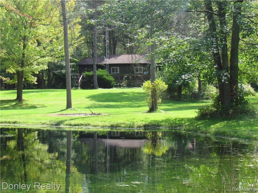 6591 Harris Road Kingston, MI 48741 - Photo 4 of 39 The back of the home looking from across the pond in the back yard. All sorts of nature out here to enjoy.