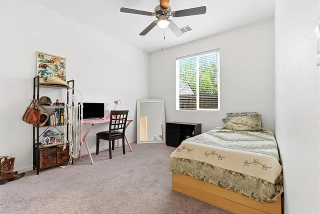 a spacious bedroom with a bed and a chandelier