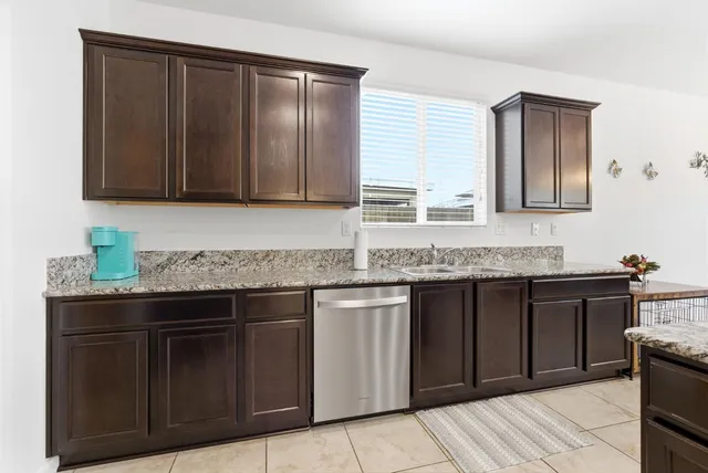 a kitchen with granite countertop cabinets sink and window