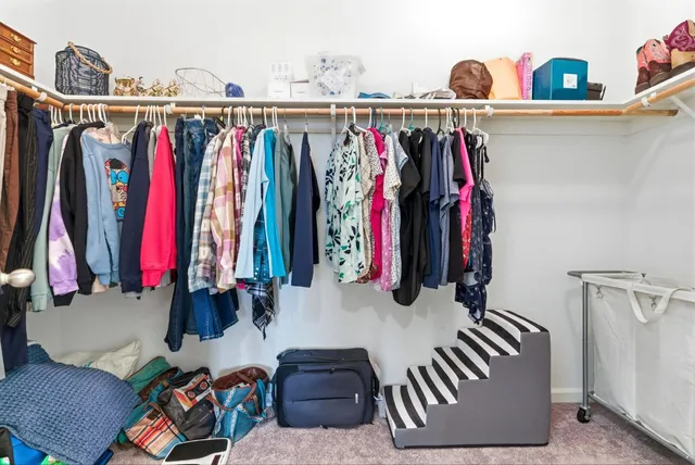 a view of walk in closet with clothes and shoes