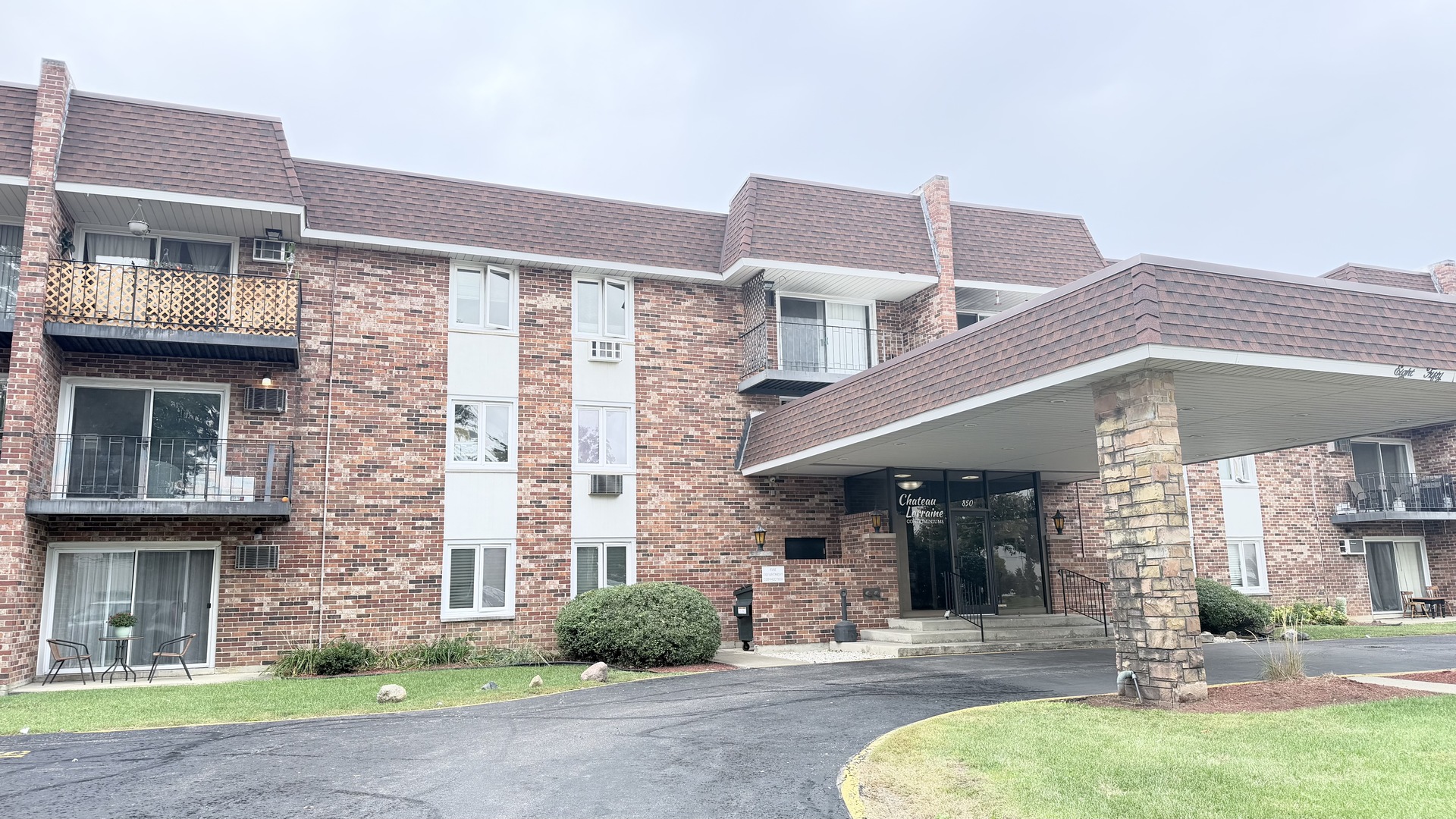 a front view of a building with a garden and plants