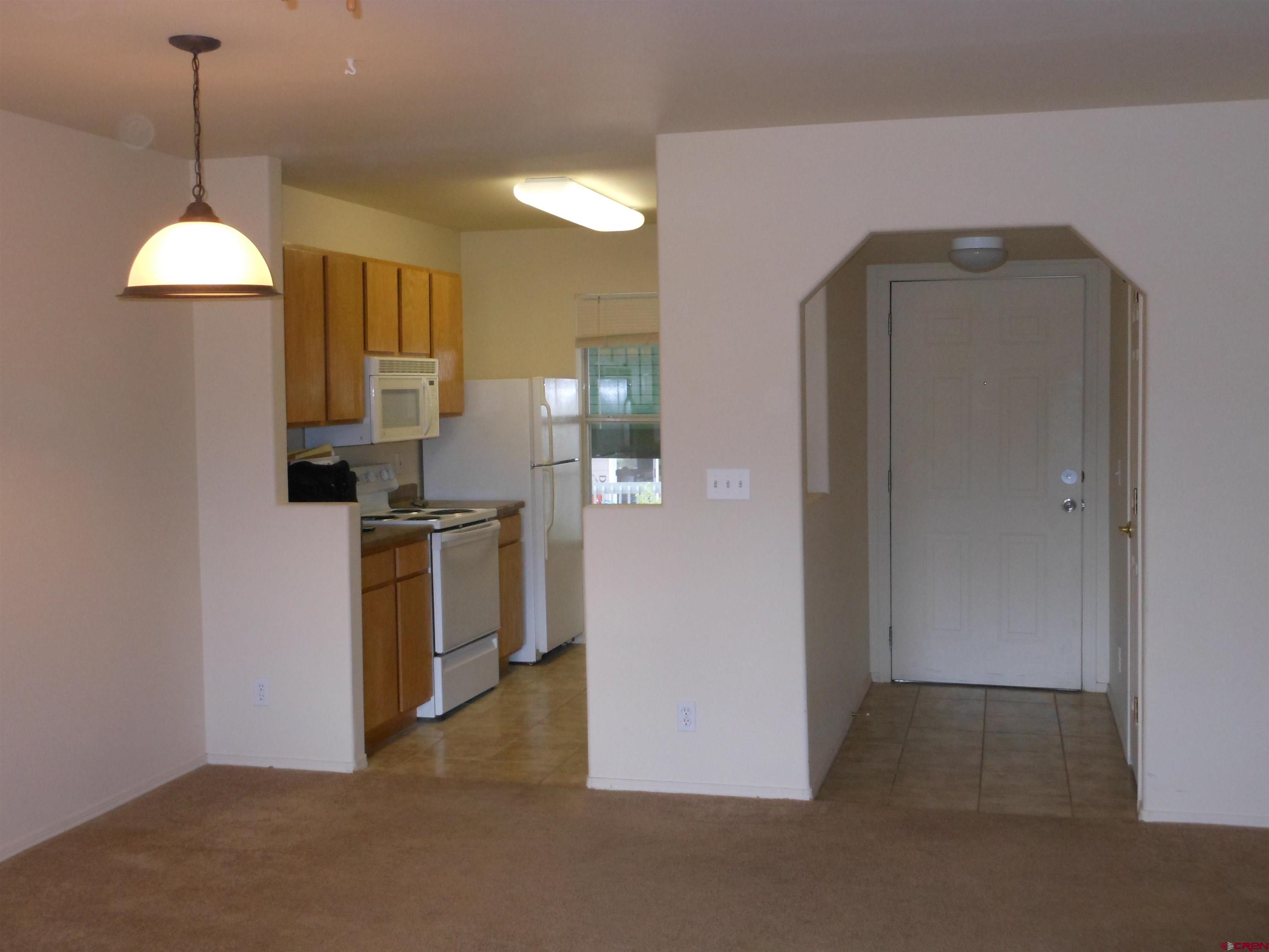 1100 Goeglein Gulch Road, Unit 211 Durango, CO 81301 - Photo 3 of 14 a kitchen with stainless steel appliances granite countertop a refrigerator a sink a stove and a wooden floors