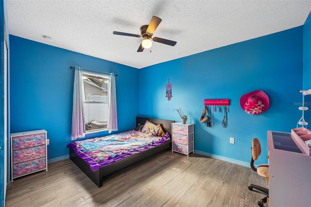 10303 Fordham Street Spring Hill, FL 34608 - Photo 16 of 25 a bedroom with a bed and a chandelier