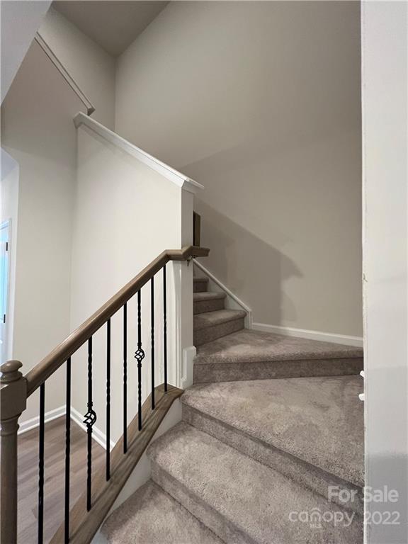 904 Pk Bnd Trail, Unit 71 Tega Cay, SC 29708 - Photo 11 of 14 a view of staircase with lots of frames on wall and windows