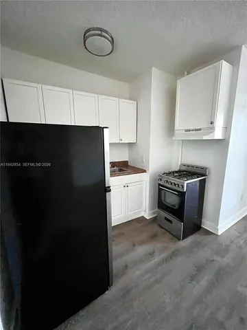 a kitchen with a refrigerator a stove and a cabinets