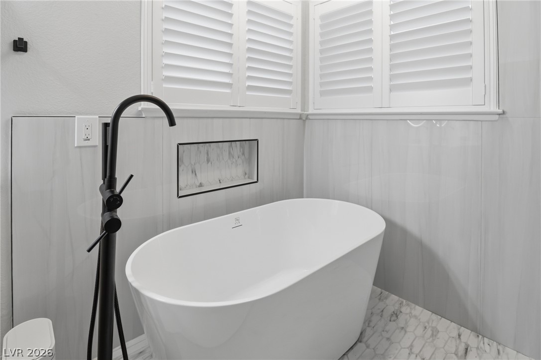 239 Highgate Street Henderson, NV 89074 - Photo 21 of 44 Retreat to a spa-inspired primary suite featuring a soaking tub, a beautifully tiled walk-in shower, dual vanities with upgraded countertops, & a spacious walk-in closet.