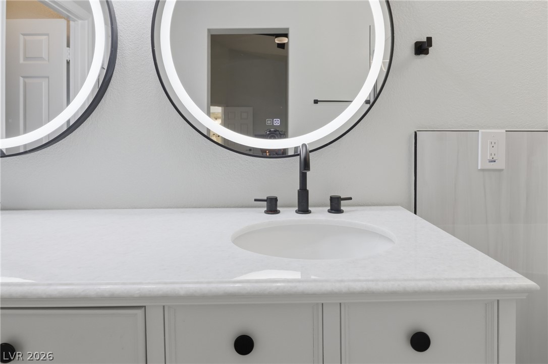 239 Highgate Street Henderson, NV 89074 - Photo 23 of 44 Retreat to a spa-inspired primary suite featuring a soaking tub, a beautifully tiled walk-in shower, dual vanities with upgraded countertops, & a spacious walk-in closet.