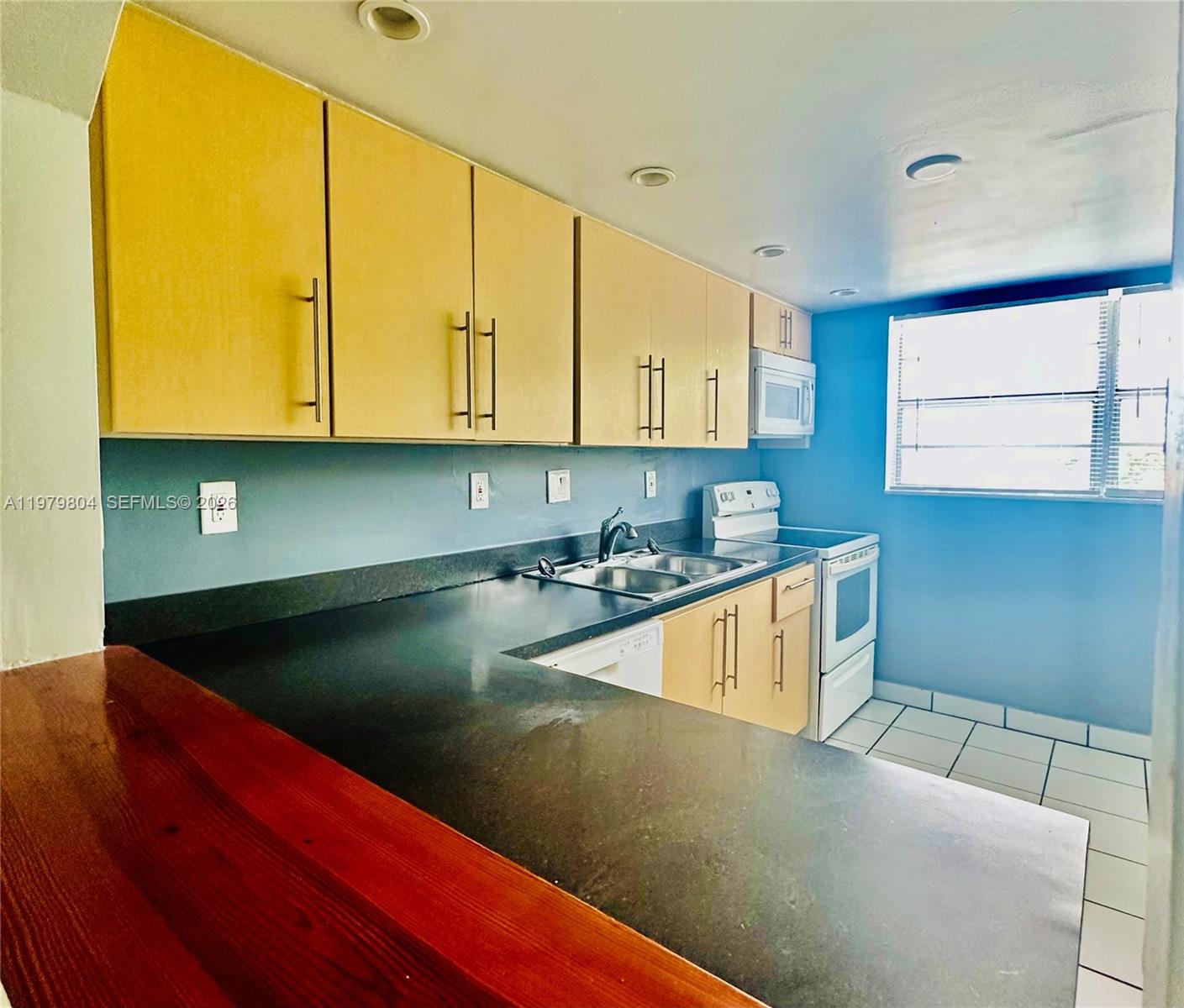 8101 Southwest 73rd Avenue, Unit 17 Miami, FL 33143 - Photo 15 of 66 a kitchen with a sink a counter top space and cabinets