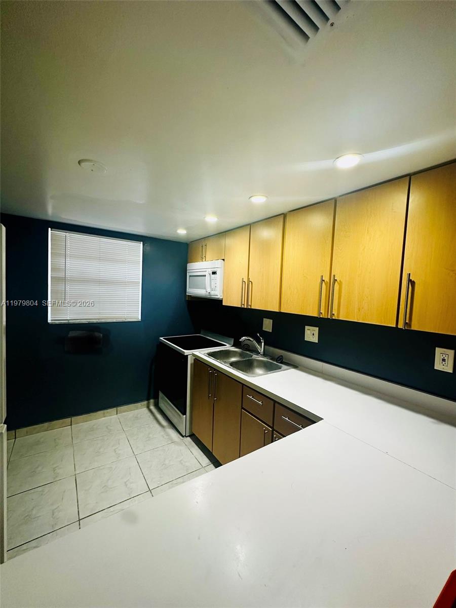 8101 Southwest 73rd Avenue, Unit 17 Miami, FL 33143 - Photo 17 of 66 a kitchen with stainless steel appliances granite countertop a sink and a microwave