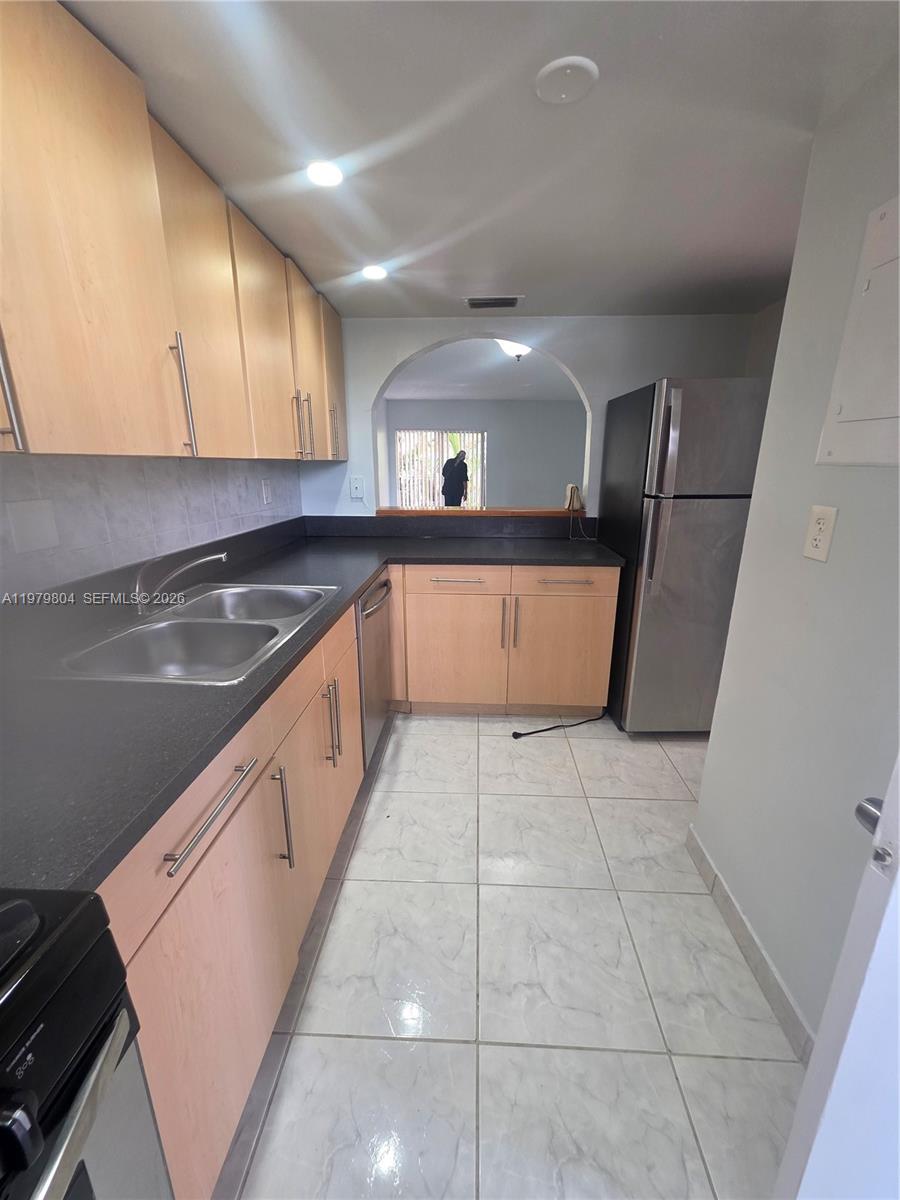 8101 Southwest 73rd Avenue, Unit 17 Miami, FL 33143 - Photo 48 of 66 a kitchen with stainless steel appliances granite countertop a sink and a stove