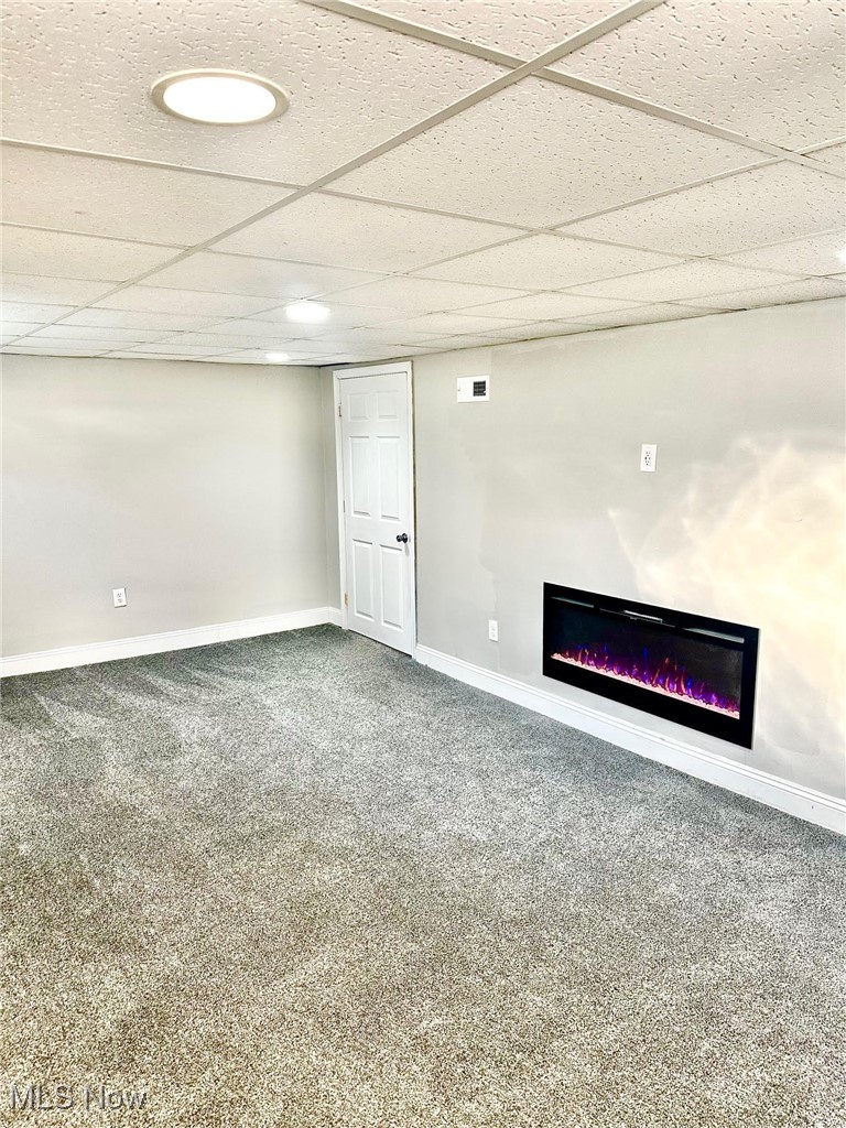 1389 Diagonal Road Akron, OH 44320 - Photo 7 of 20 Finished below grade area featuring carpet floors, baseboards, a glass covered fireplace, and a paneled ceiling