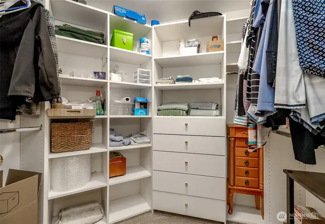 a view of walk in closet with clothes and shoes