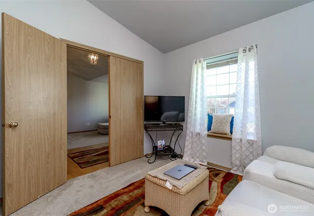 a living room with furniture a flat screen tv and a window