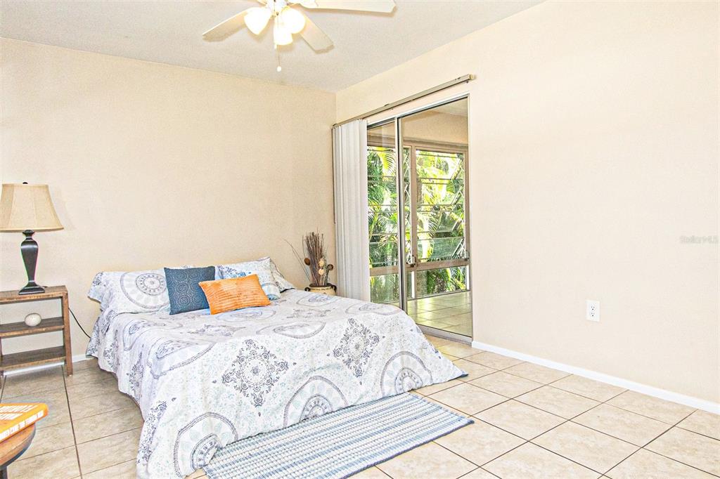 1433 South Belcher Road, Unit F11 Clearwater, FL 33764 - Photo 11 of 21 a bedroom with a bed and a chandelier