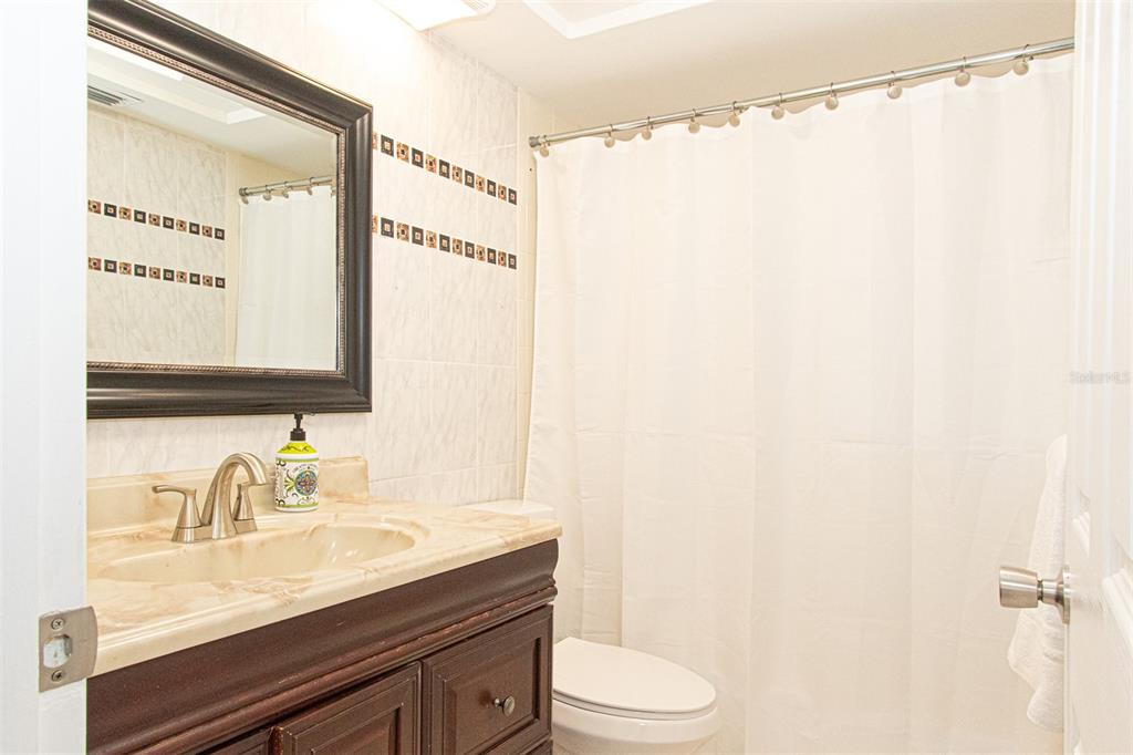 1433 South Belcher Road, Unit F11 Clearwater, FL 33764 - Photo 18 of 21 a bathroom with a granite countertop sink mirror vanity and toilet