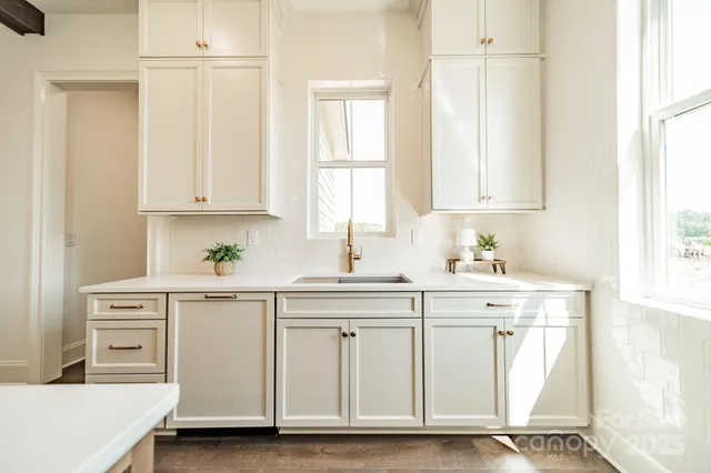 a kitchen with white cabinets and white appliances