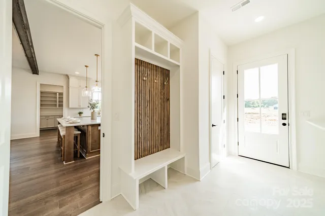 a view of a hallway with wooden floor windows and a living room