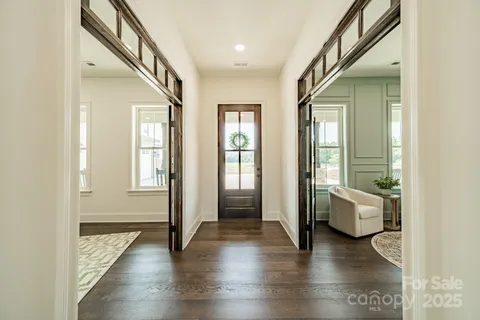 a hallway with wooden floor and stairs