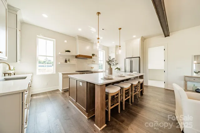 a kitchen with kitchen island a sink stove and wooden floor