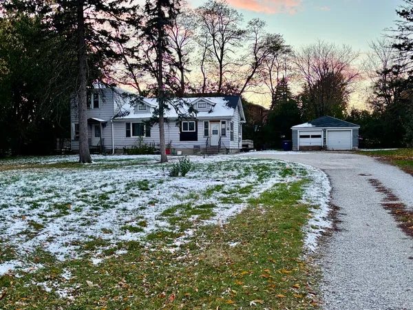 a front view of a house with a yard and trees