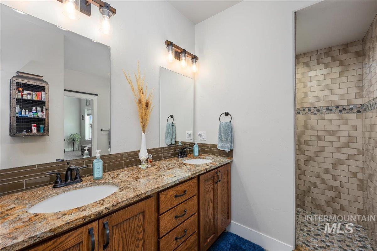 40 Bell Rapids Road Hagerman, ID 83332 - Photo 25 of 50 Bathroom featuring double vanity, a walk in shower, and tasteful backsplash