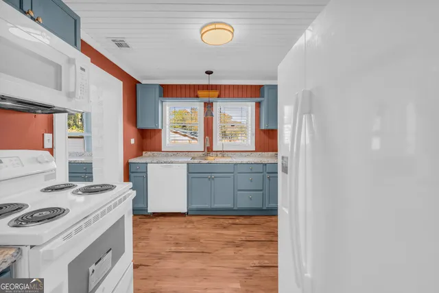 a kitchen with cabinets appliances and a window