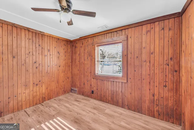 a bedroom with a bed and a chandelier fan