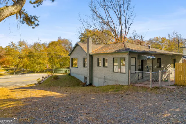 a view of a large building with large trees and plants