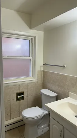 a bathroom with a toilet a sink and mirror
