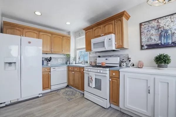 a kitchen with granite countertop white cabinets and white appliances