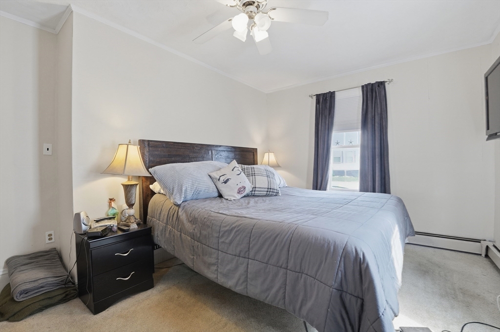 203 South Main Street Acushnet, MA 02743 - Photo 17 of 34 a bedroom with a bed and a chandelier