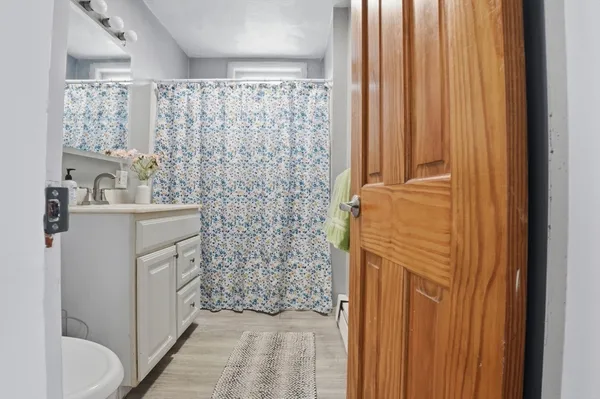 a bathroom with a sink a toilet and shower curtain