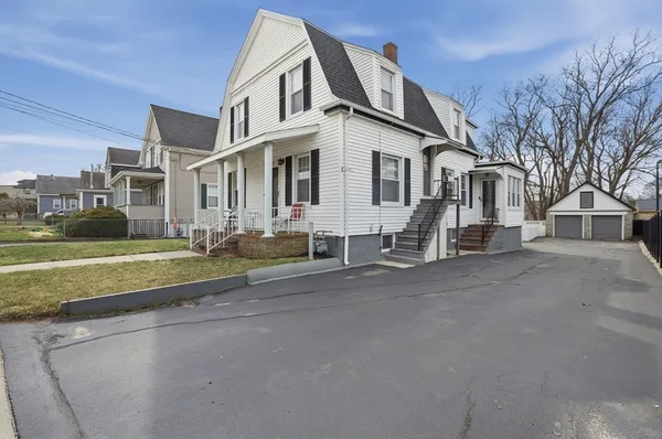 a view of a white house with a big yard and large trees