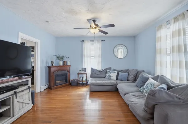 a living room with furniture a flat screen tv and a fireplace