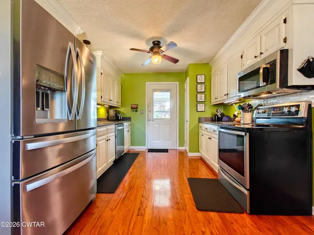a kitchen with stainless steel appliances a stove a sink and a refrigerator