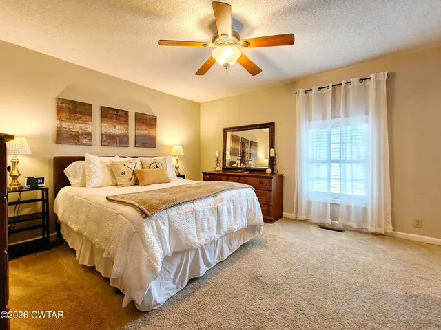 a spacious bedroom with a bed and a chandelier