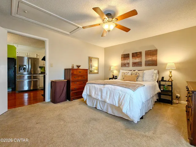 a spacious bedroom with a bed and dresser