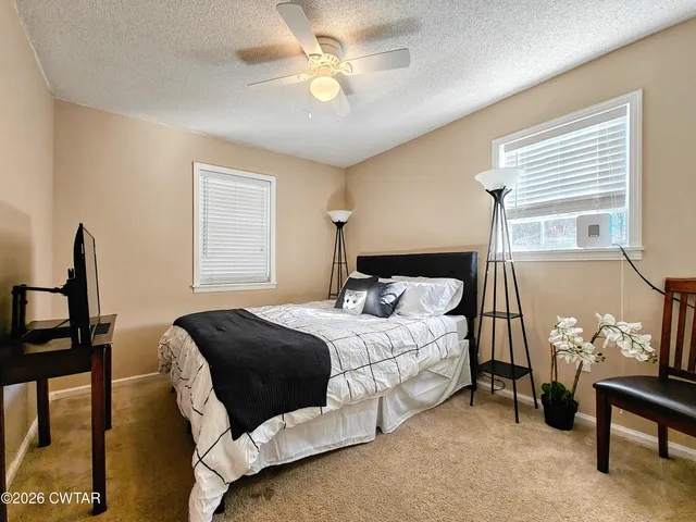 a bedroom with a large bed and a chandelier