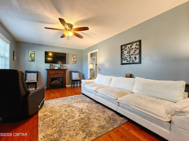 a living room with furniture a fireplace and a flat screen tv