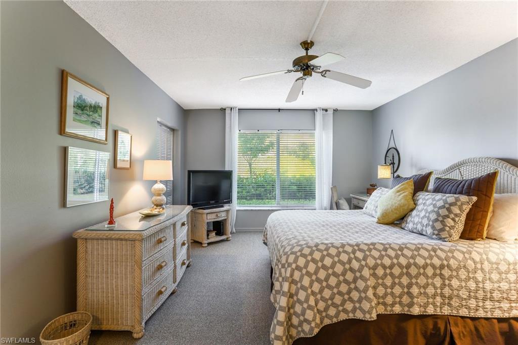 4155 Crayton Road, Unit 108 Naples, FL 34103 - Photo 15 of 32 a bedroom with a bed and wooden floor