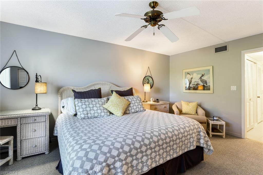4155 Crayton Road, Unit 108 Naples, FL 34103 - Photo 16 of 32 a bedroom with a bed and a chandelier