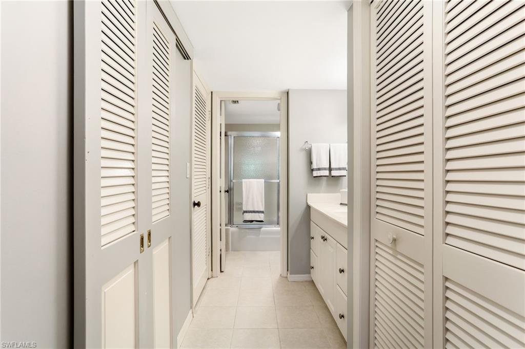 4155 Crayton Road, Unit 108 Naples, FL 34103 - Photo 17 of 32 a bathroom with a double vanity sink and mirror